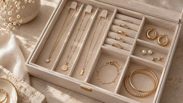 Gold-tone jewelry organized in separate compartments of a jewelry box
